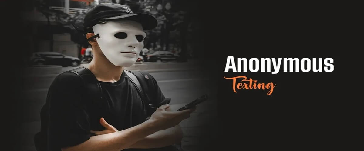 A man wearing an anonymous mask standing on the street holding his phone